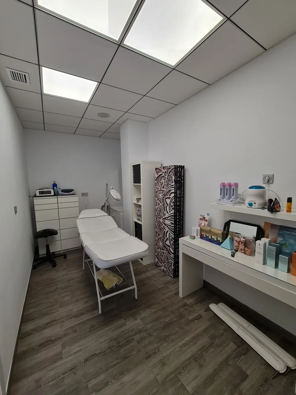 Cabina de estética con camilla y productos de tratamiento